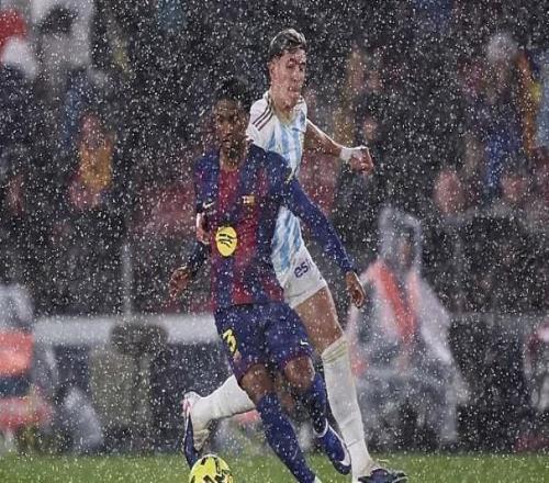 暴雨傾瀉進(jìn)諾坎普球場，記者紛紛在媒體席上撐起雨傘工作